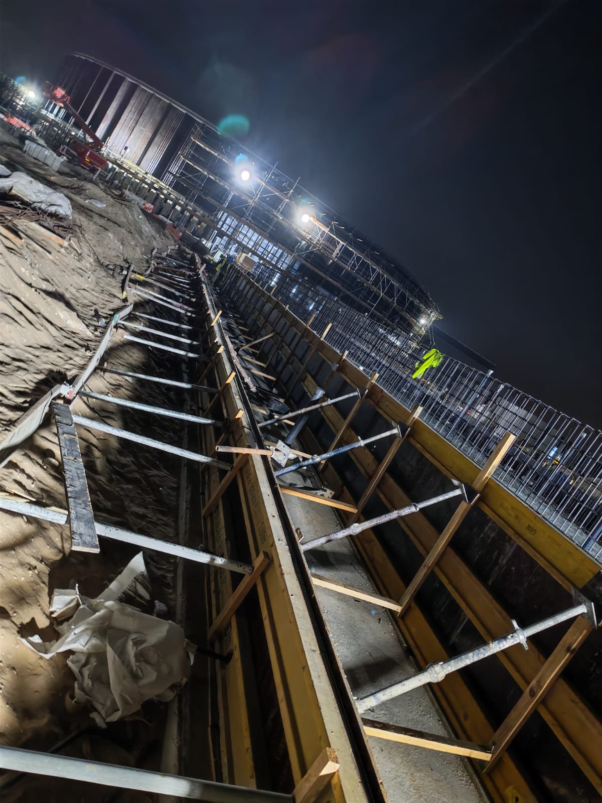 Night excavation and shoring works on an active construction site